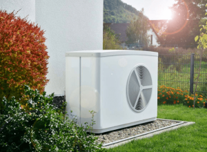 Wärmepumpe im Altbau neben modernisiertem Wohnhaus im Garten